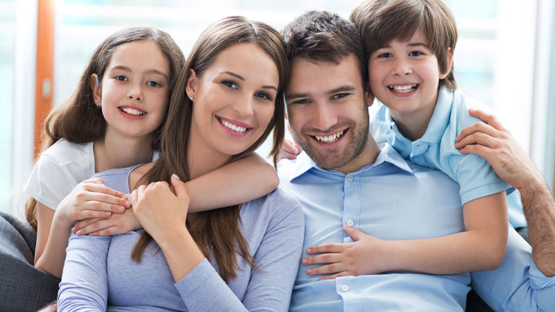 picture of a family of four smiling because they have a great family dentist