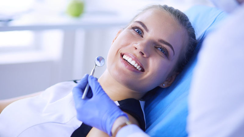 a new dental patient smiling during a dental examination.